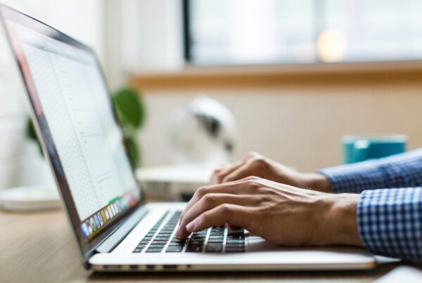 person typing on silver Macbook