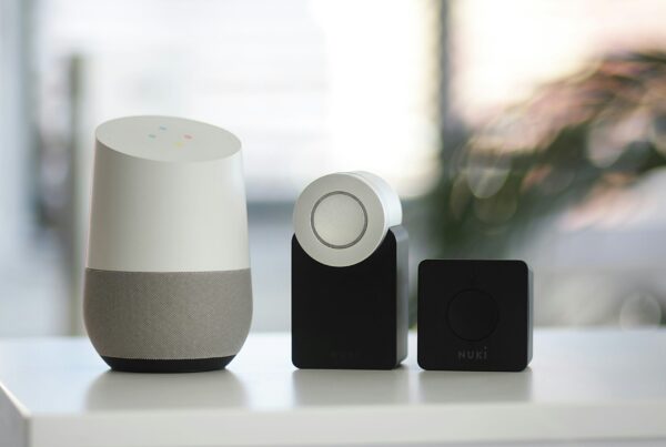 white and gray Google smart speaker and wo black speakers